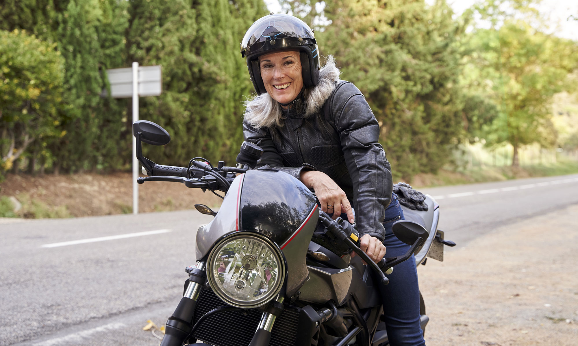 Leende kvinna sitter på en motorcykel